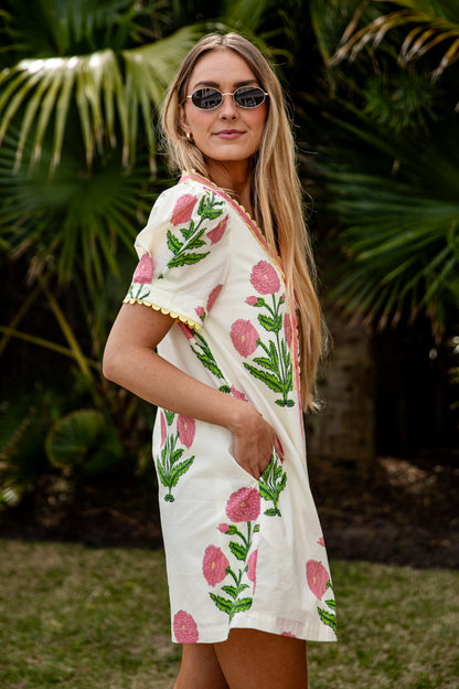 Woman wearing a floral dress with palm trees in the background