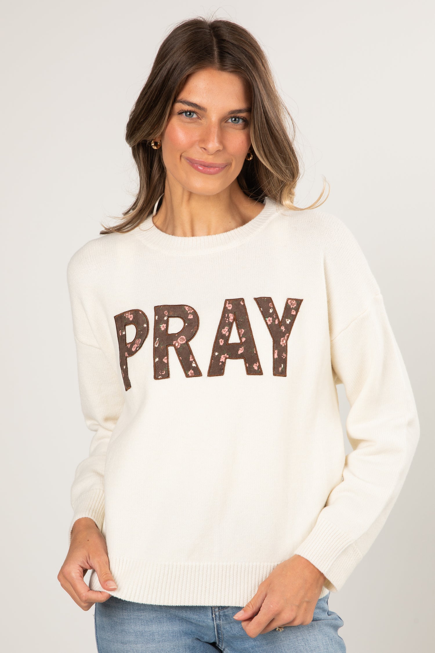 Woman wearing a white sweater with &