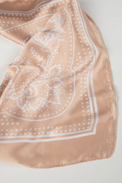 Beige scarf with white floral pattern on a light gray background