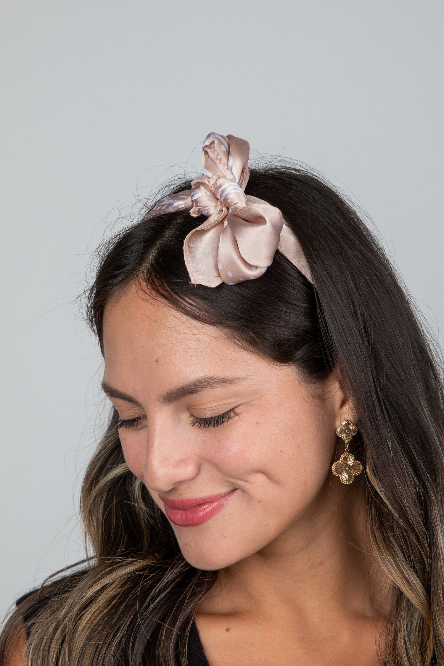 Woman wearing a pink hair bow with a gray background