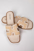 Pair of beige sandals with brown soles on a light gray background