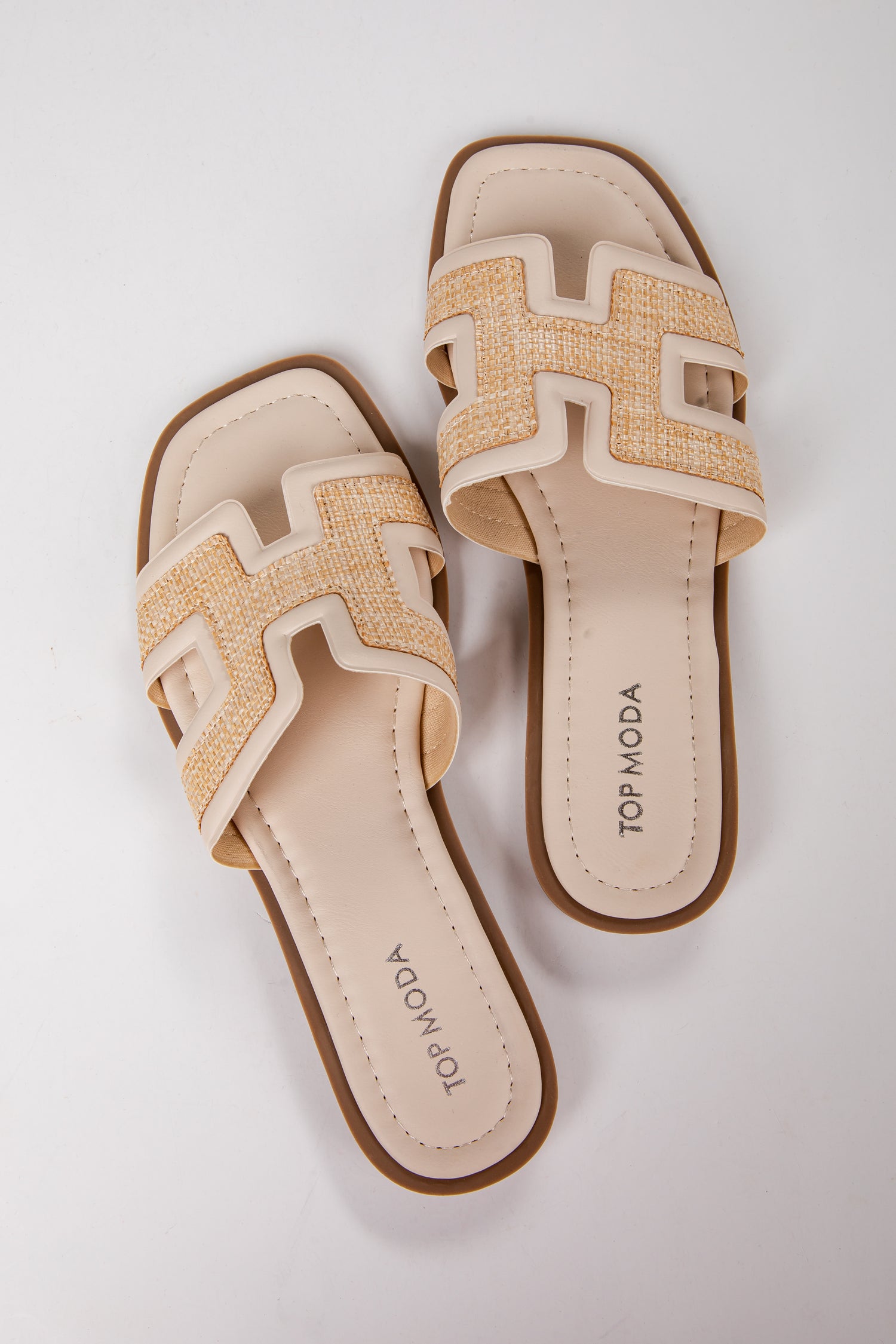 Pair of beige sandals with woven design on a white background
