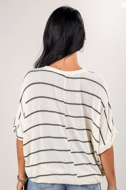 Woman wearing a striped sweater with a plain background