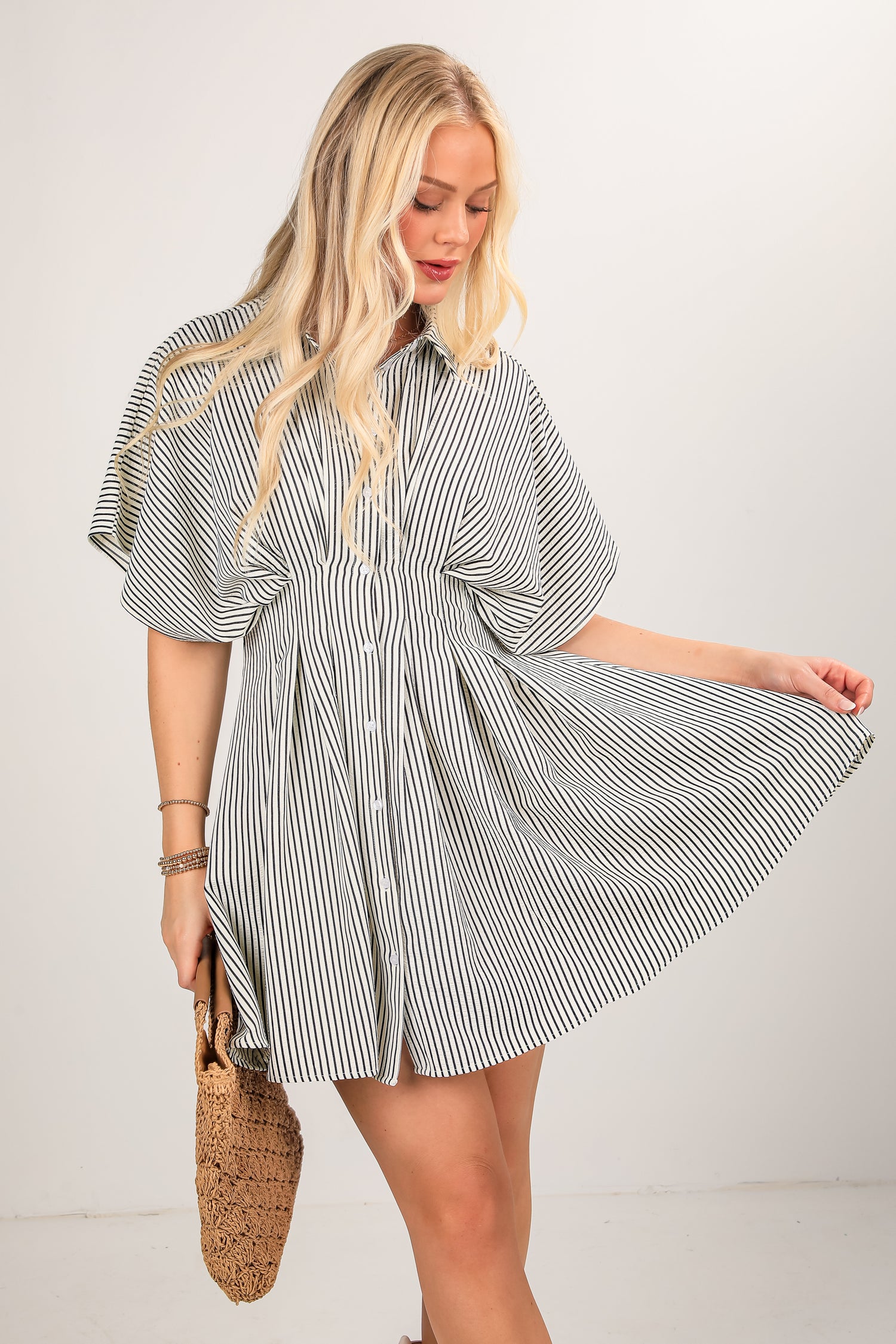 Woman wearing a striped shirt dress with a white background