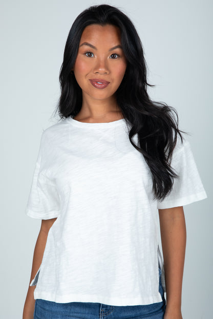 Woman wearing a white t-shirt against a plain background