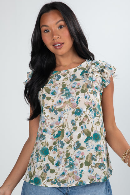 Woman wearing a floral top against a plain background