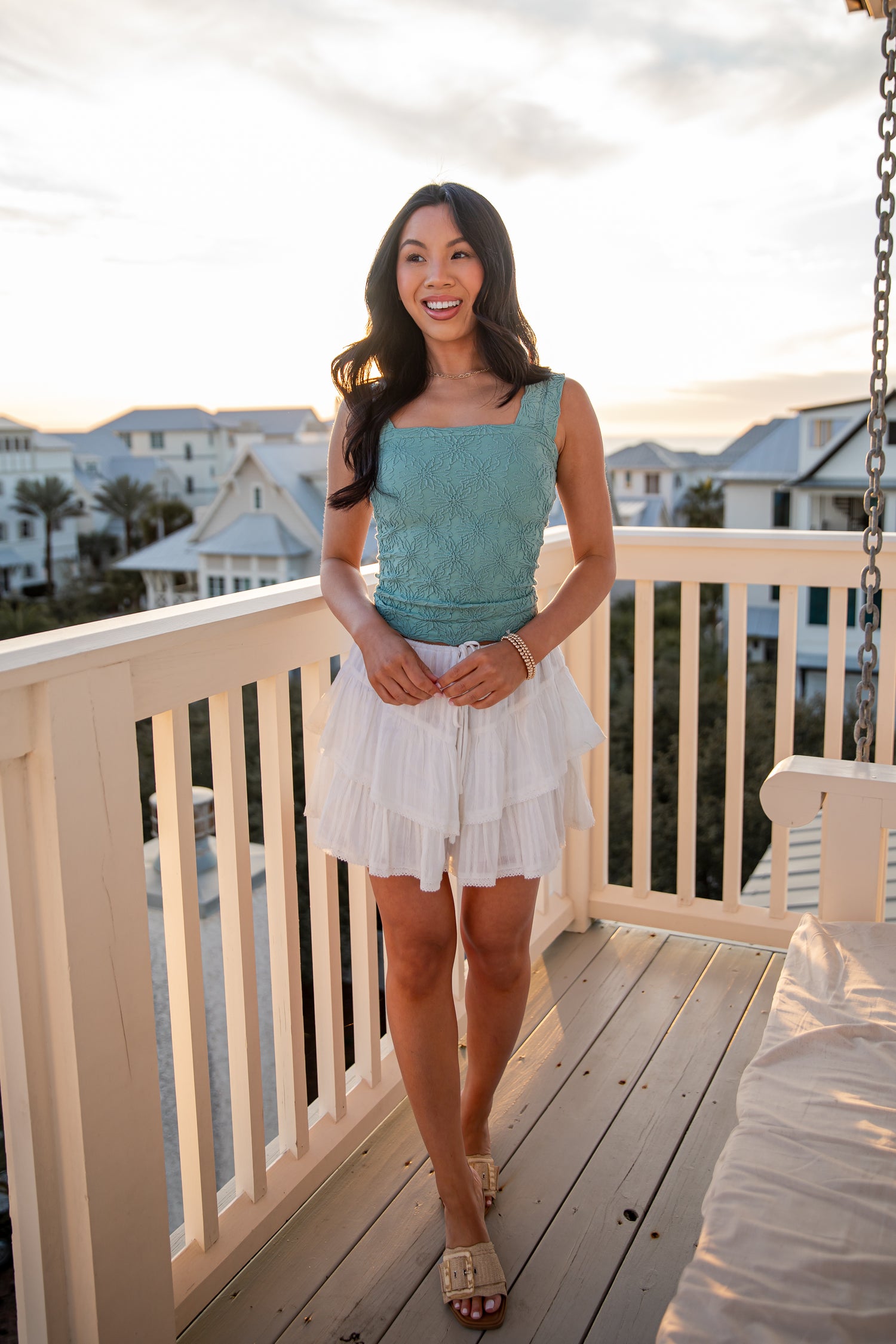 Woman standing on a balcony with a scenic background