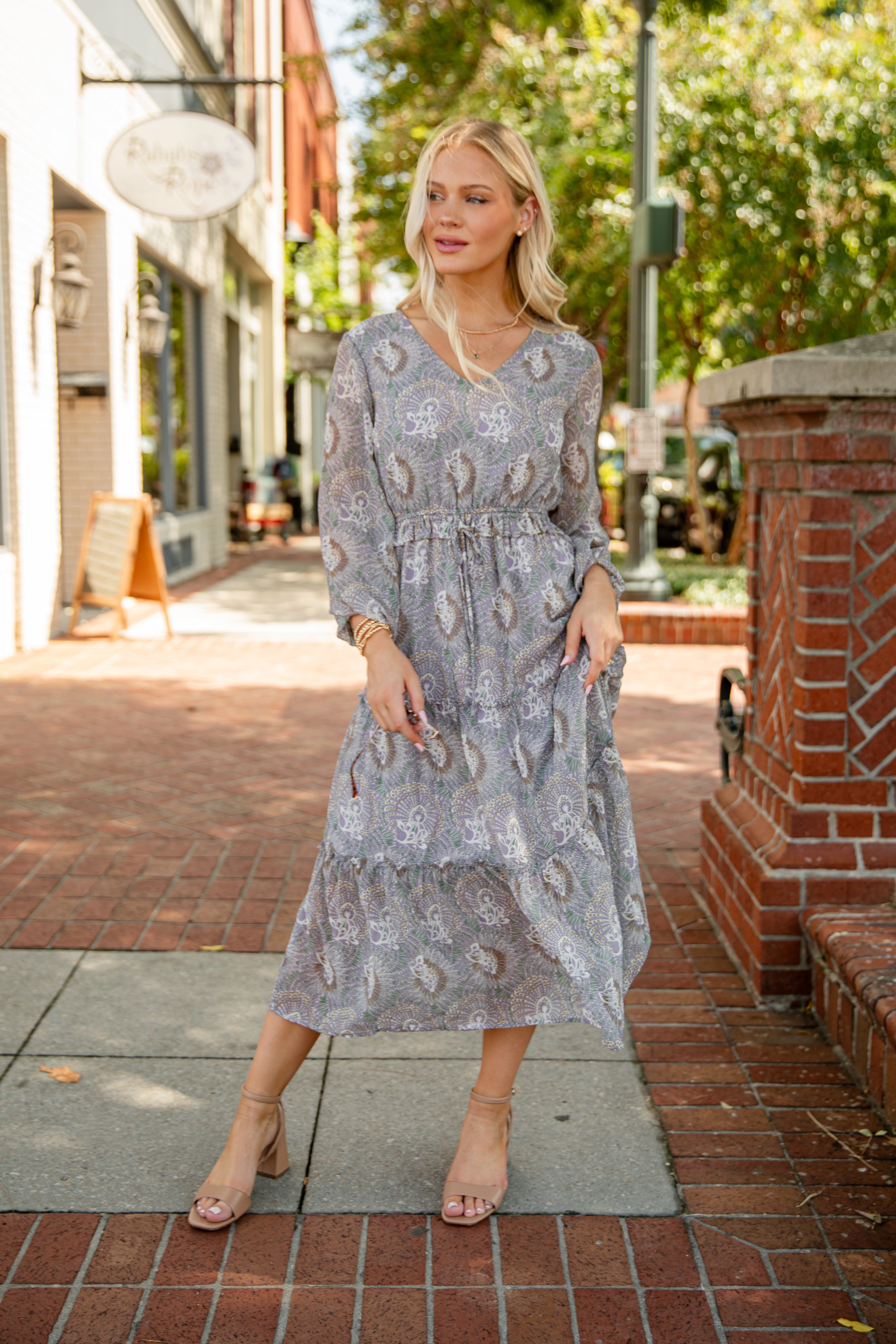Woman in a floral dress standing on a city street