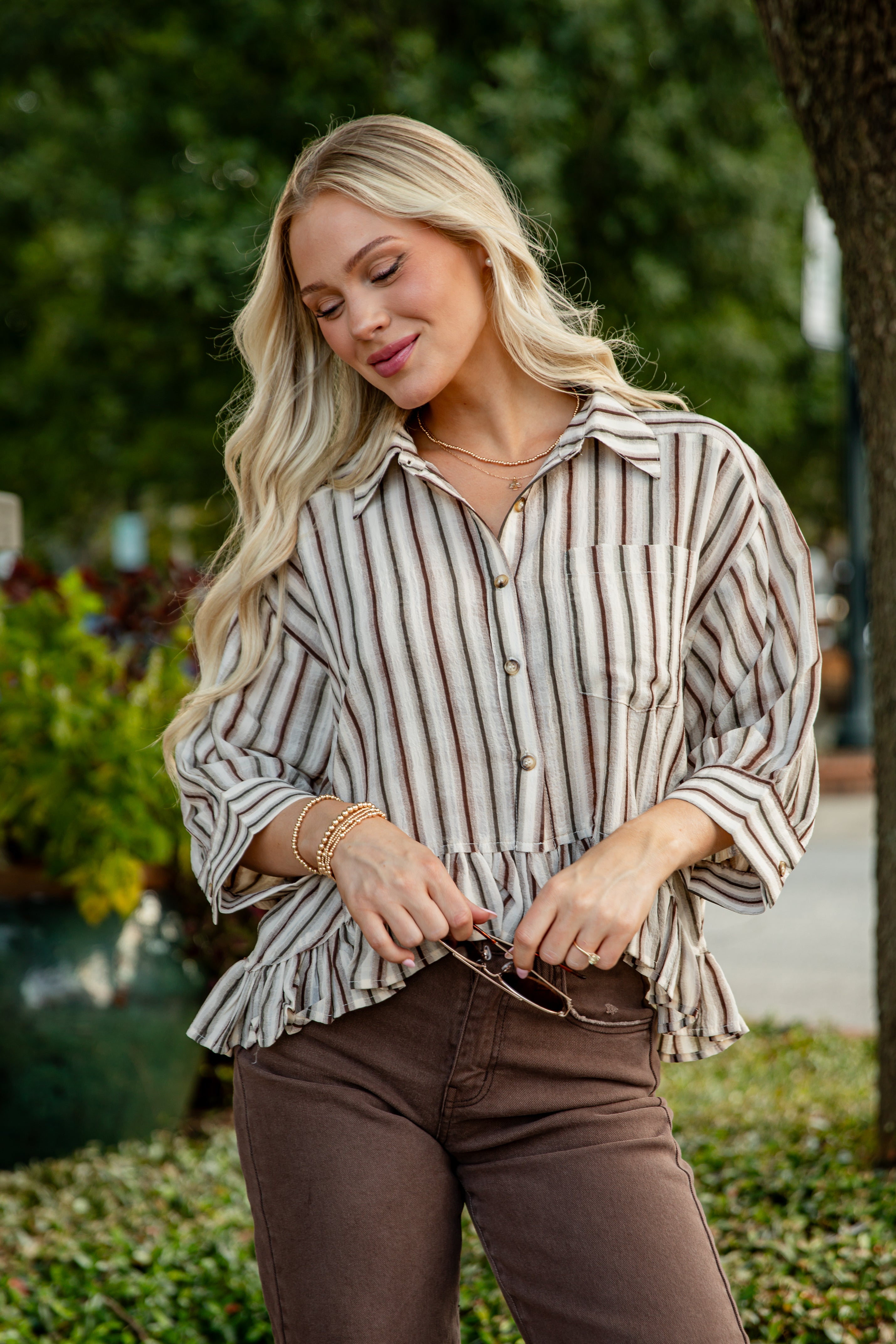 Woman wearing a striped shirt and brown pants outdoors