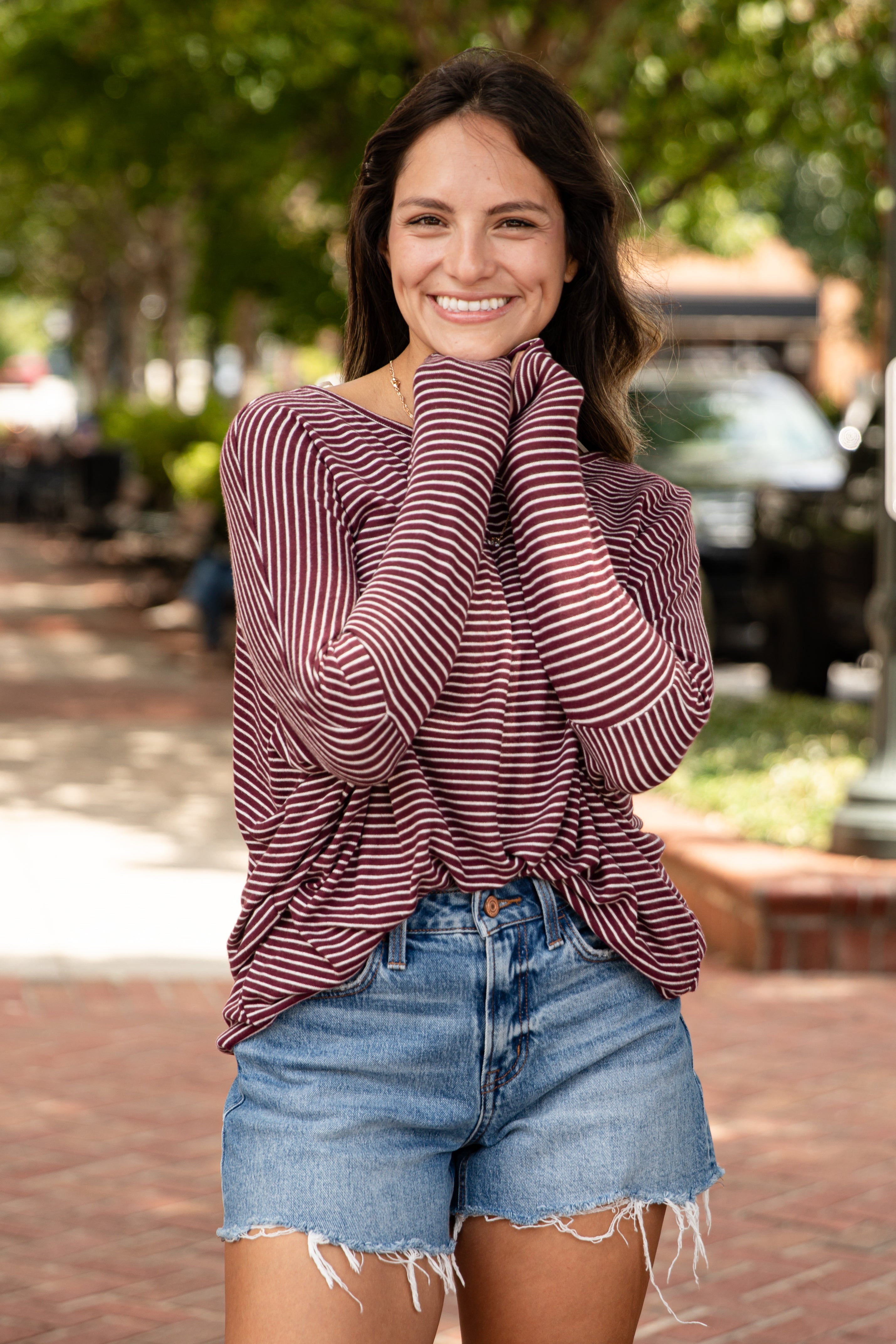 Woman wearing a striped shirt and denim shorts outdoors