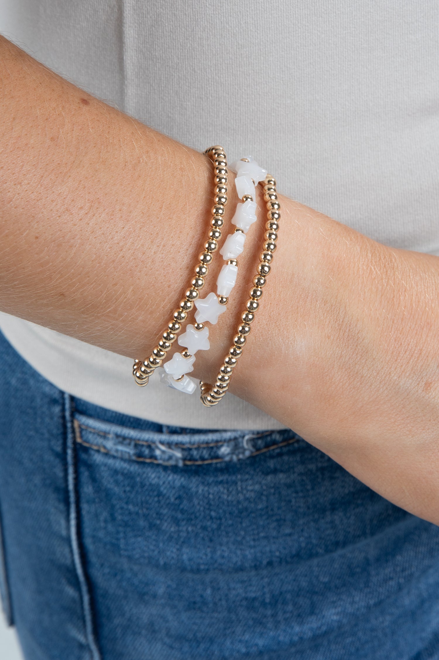 Close-up of a wrist wearing two bracelets with a neutral background