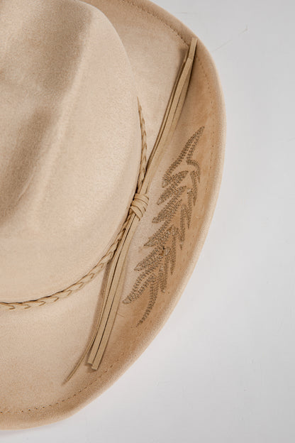 Beige hat with feather detail on a light gray background