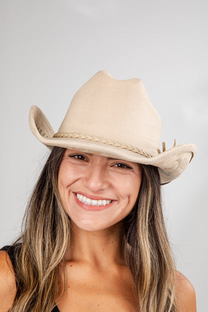Woman wearing a beige cowboy hat against a plain background