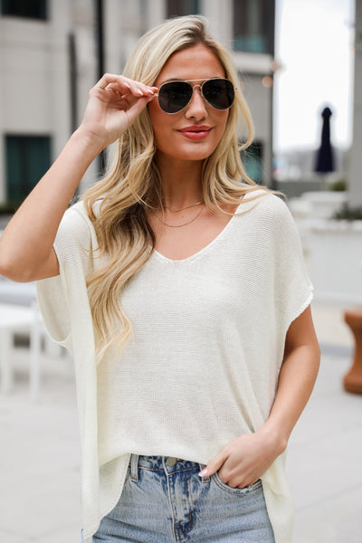 off white knit sweater, Eliza Lightweight Knit Top is the perfect spring sweater. Lightweight knit sweater, with v-neck, short sleeves, and oversized fit. Pairs well with denim. Online boutique. 
