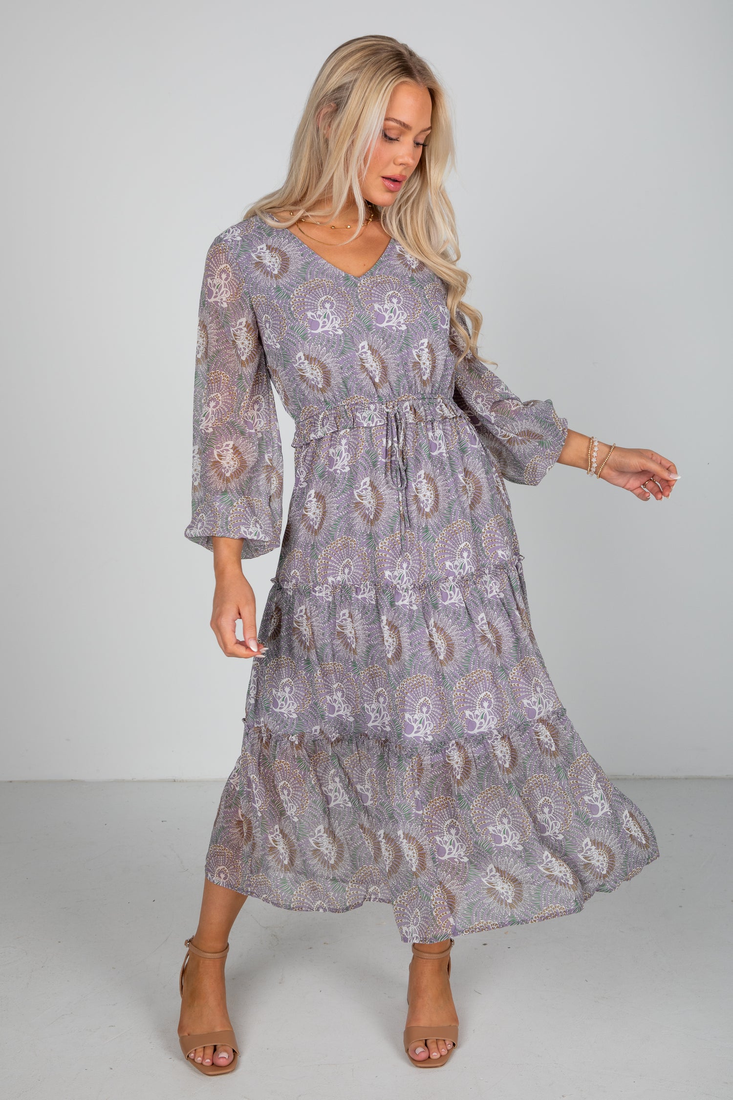 Woman wearing a patterned dress on a plain background