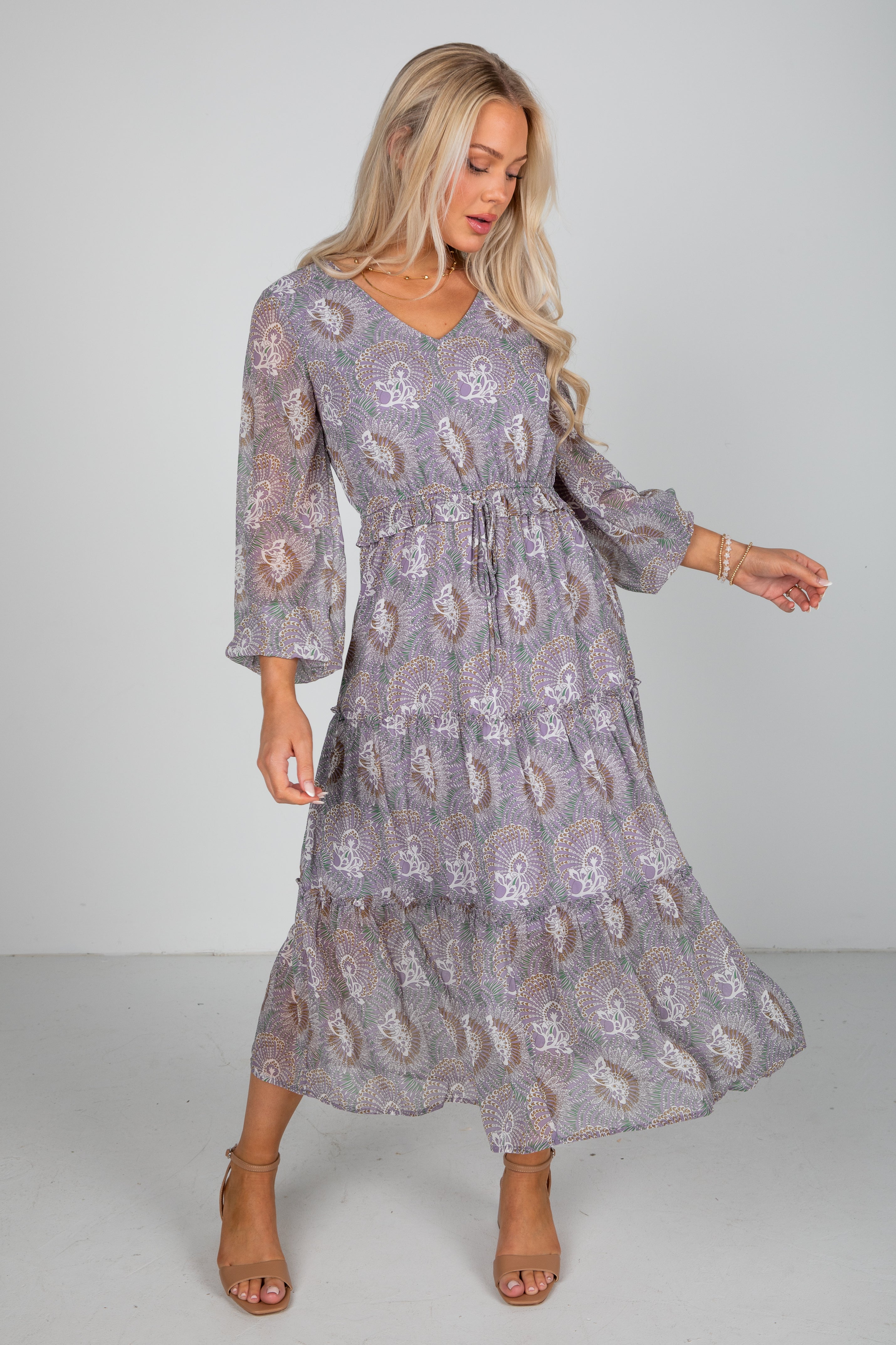 Woman wearing a patterned dress on a plain background