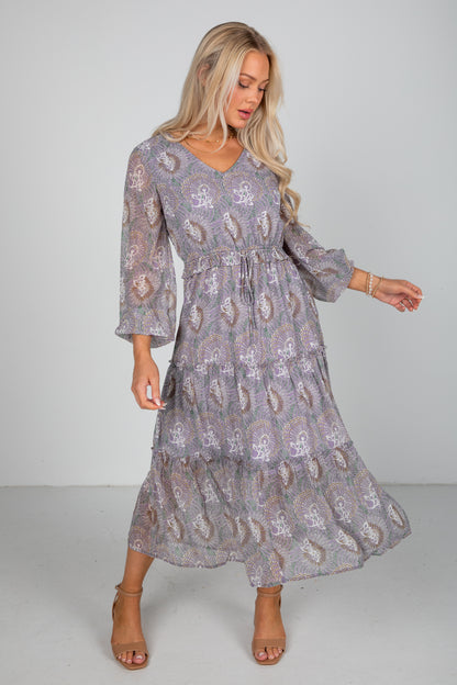 Woman wearing a patterned dress on a plain background