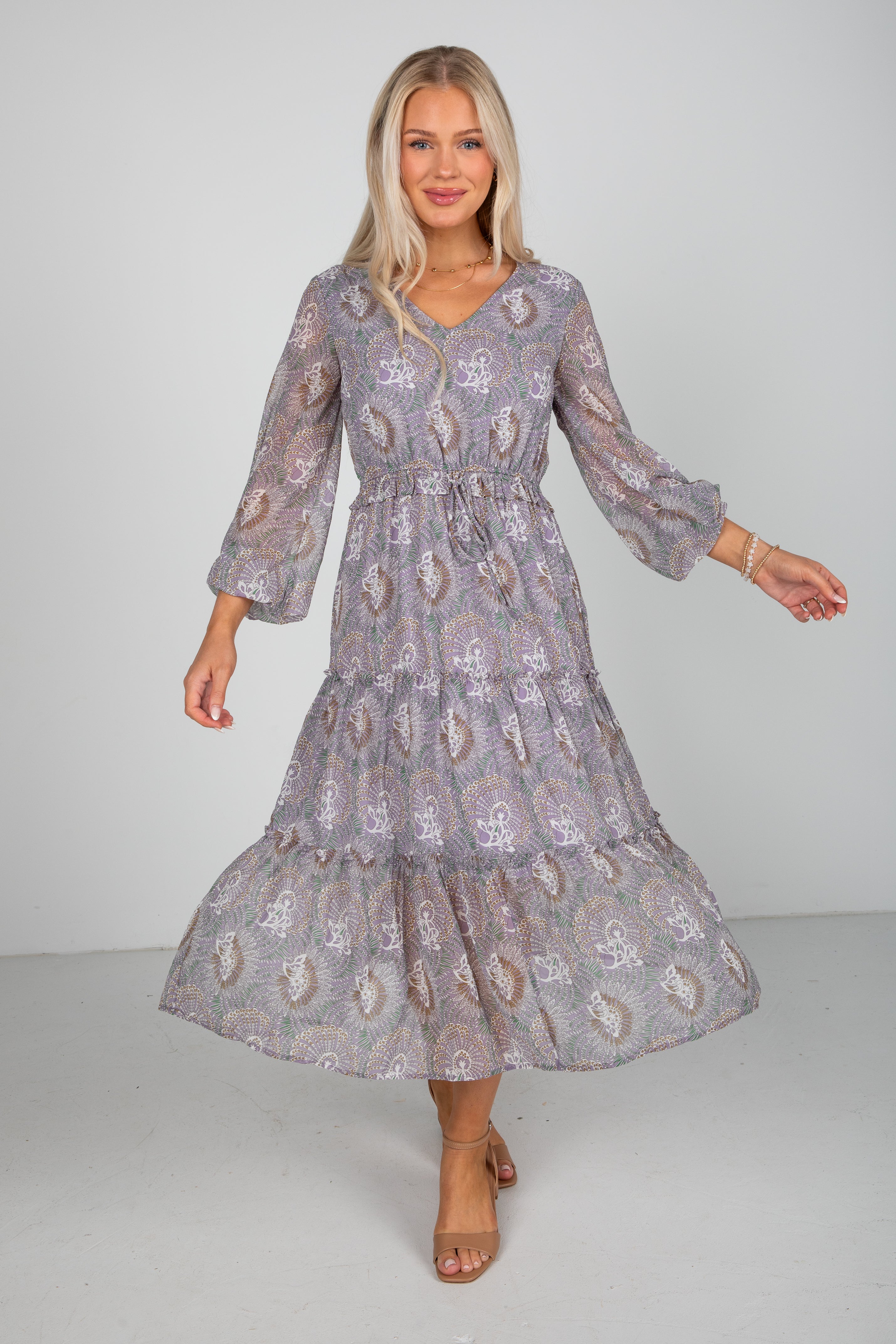 Woman wearing a patterned dress against a plain background