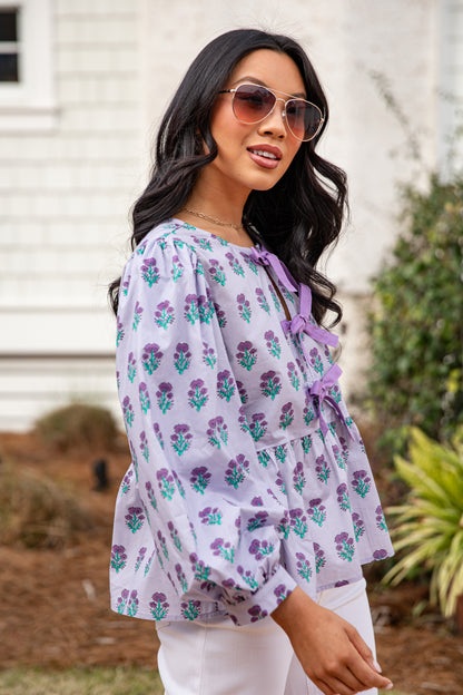 Woman wearing a floral blouse with a blurred background