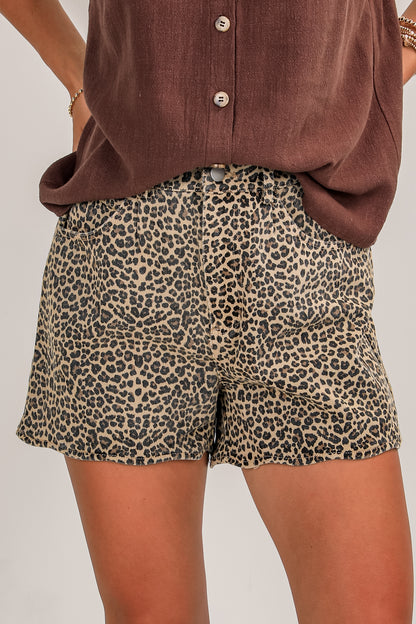 Leopard print shorts worn with a brown top on a plain background