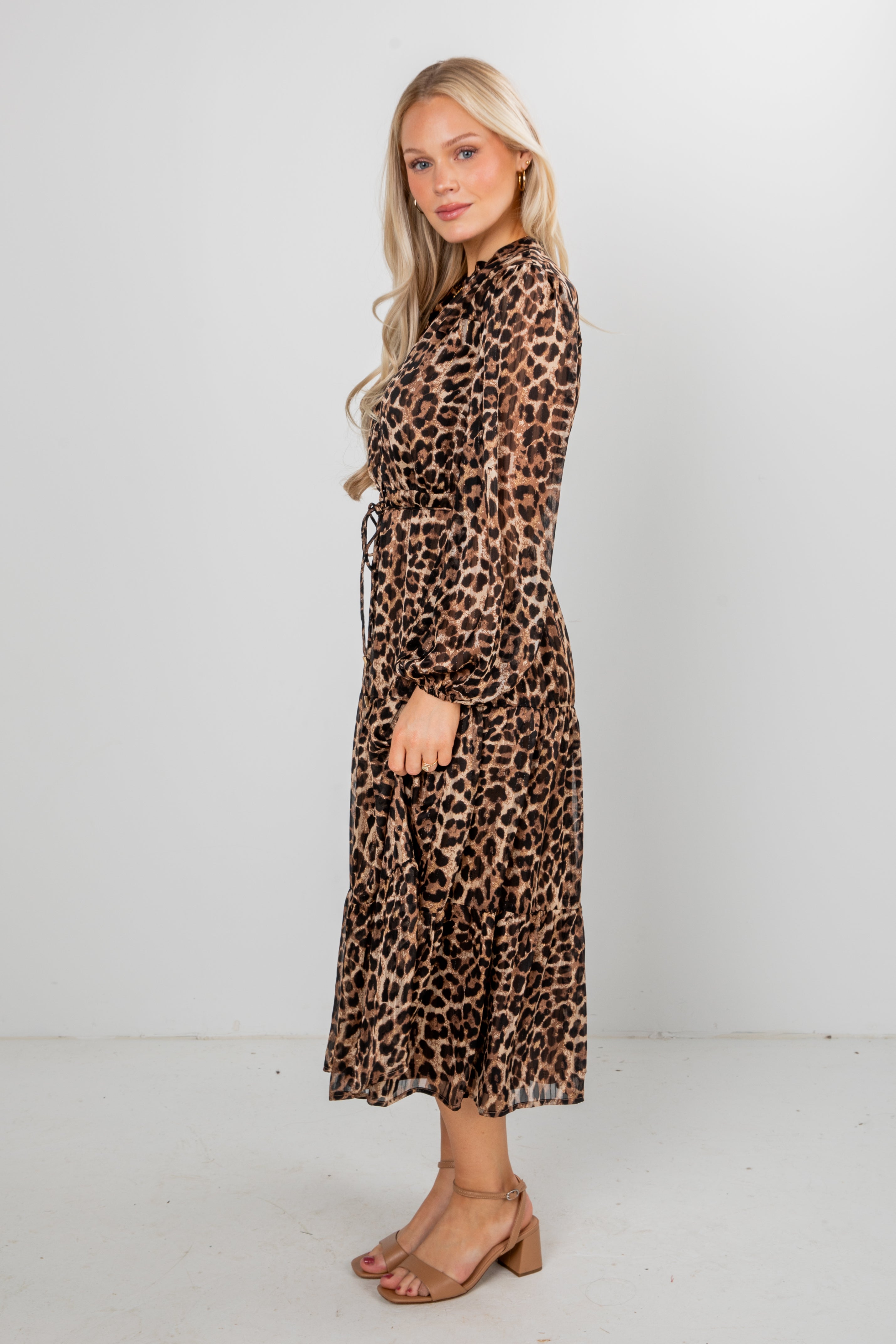 Woman wearing a leopard print dress against a white background