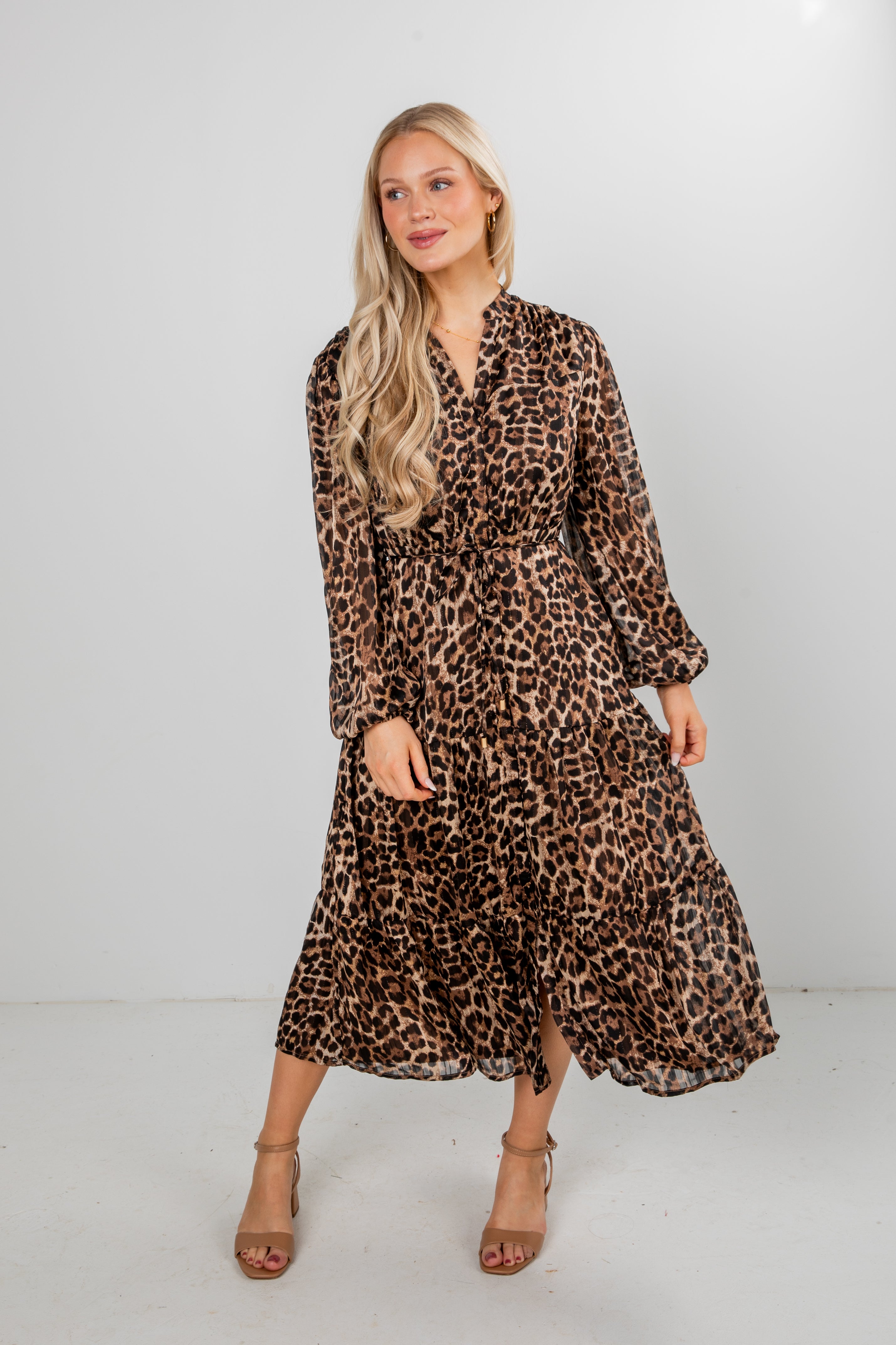 Woman wearing a leopard print dress against a white background