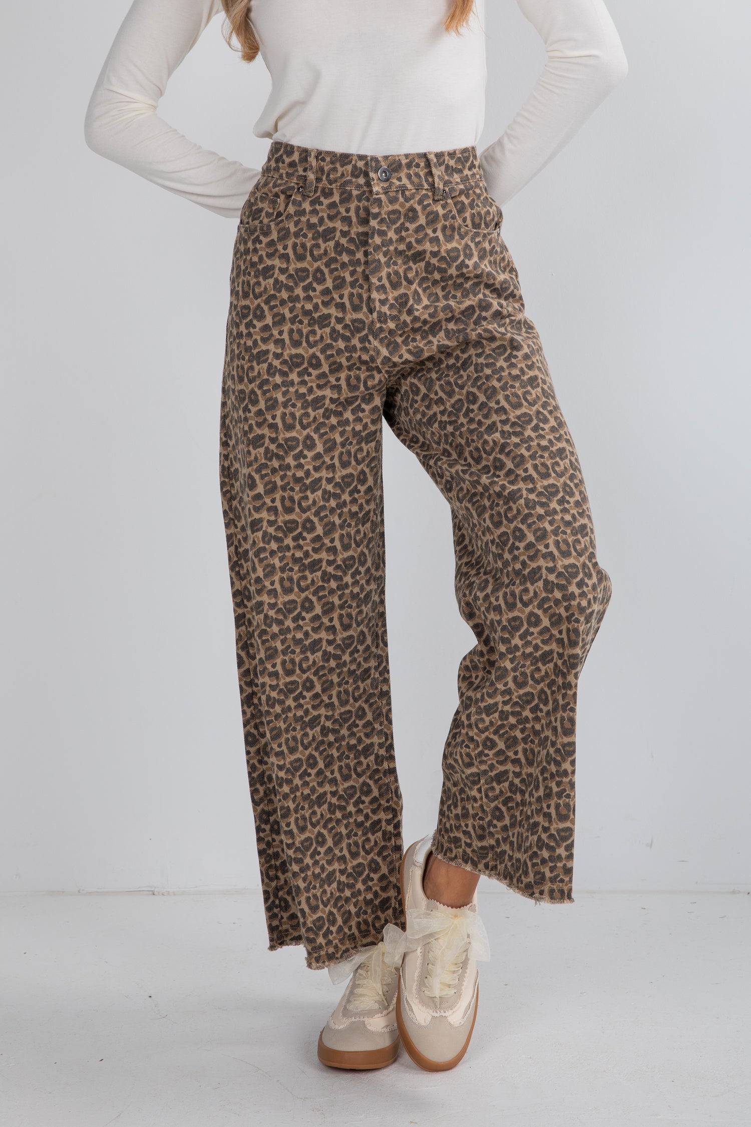 Person wearing leopard print pants on a white background