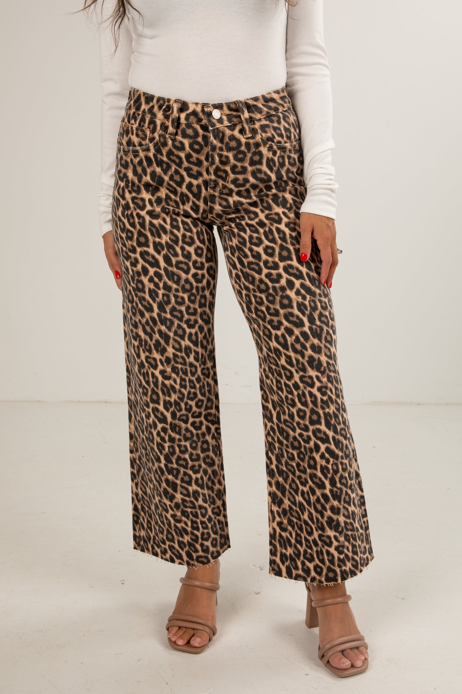 Person wearing leopard print pants on a plain background