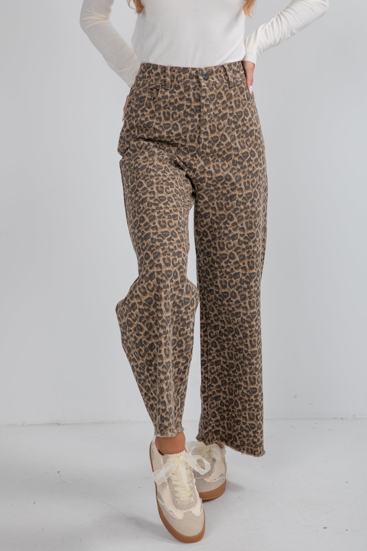 Leopard print pants worn by a person on a white background