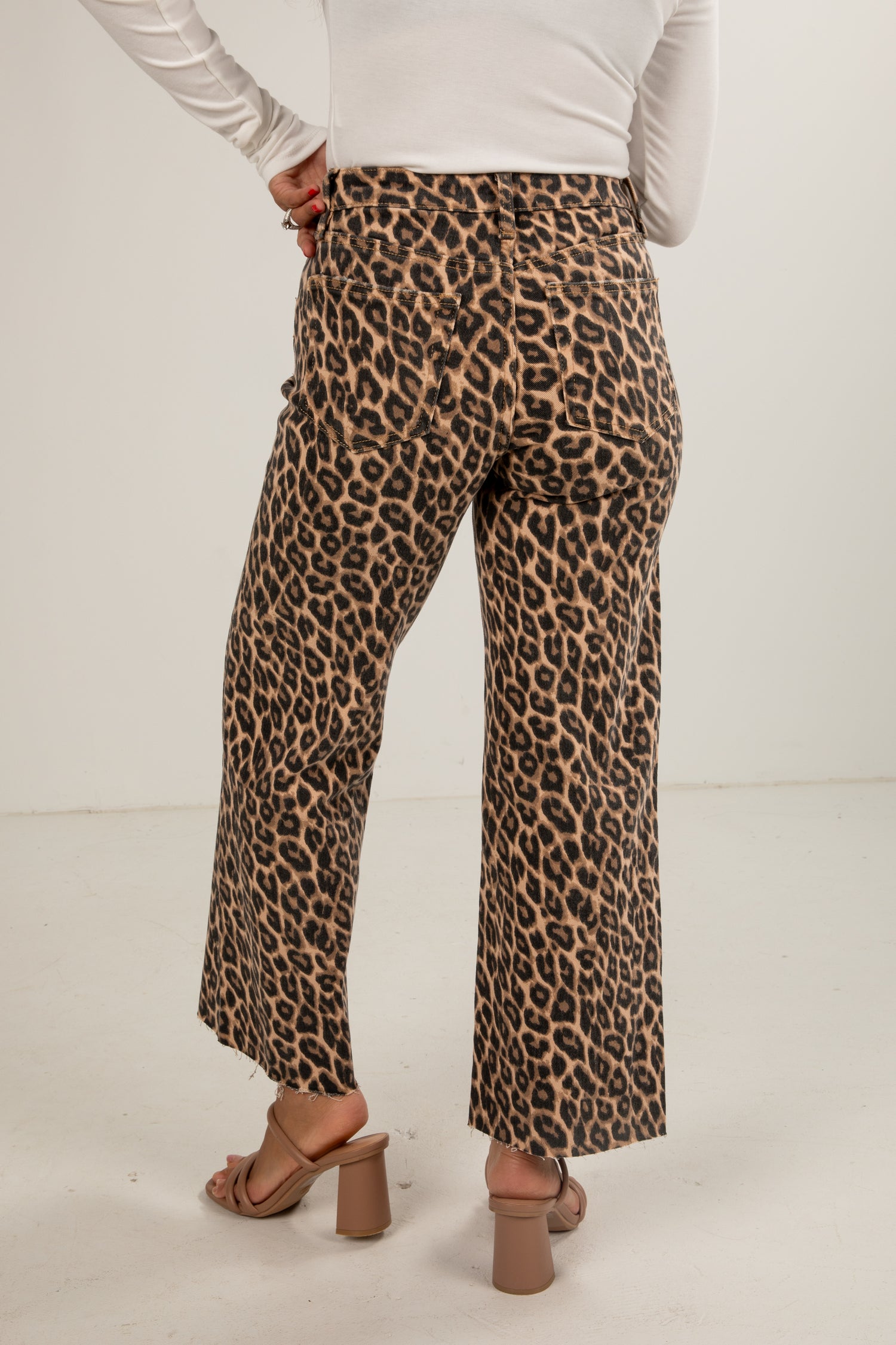 Leopard print pants worn by a person on a white background
