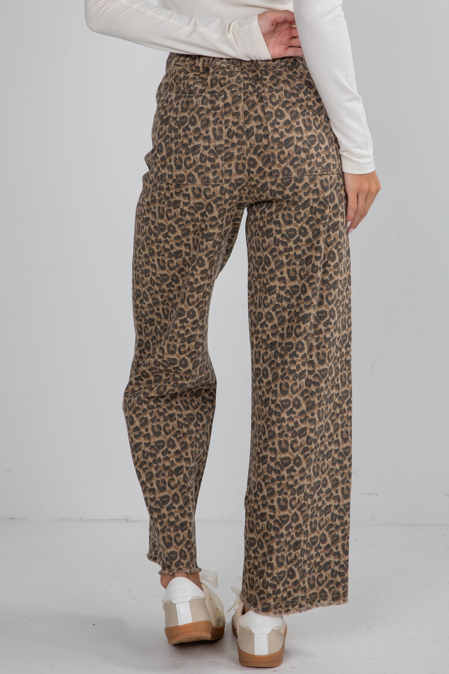 Leopard print pants worn by a person on a plain background