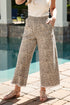 Person wearing leopard print pants standing by a pool