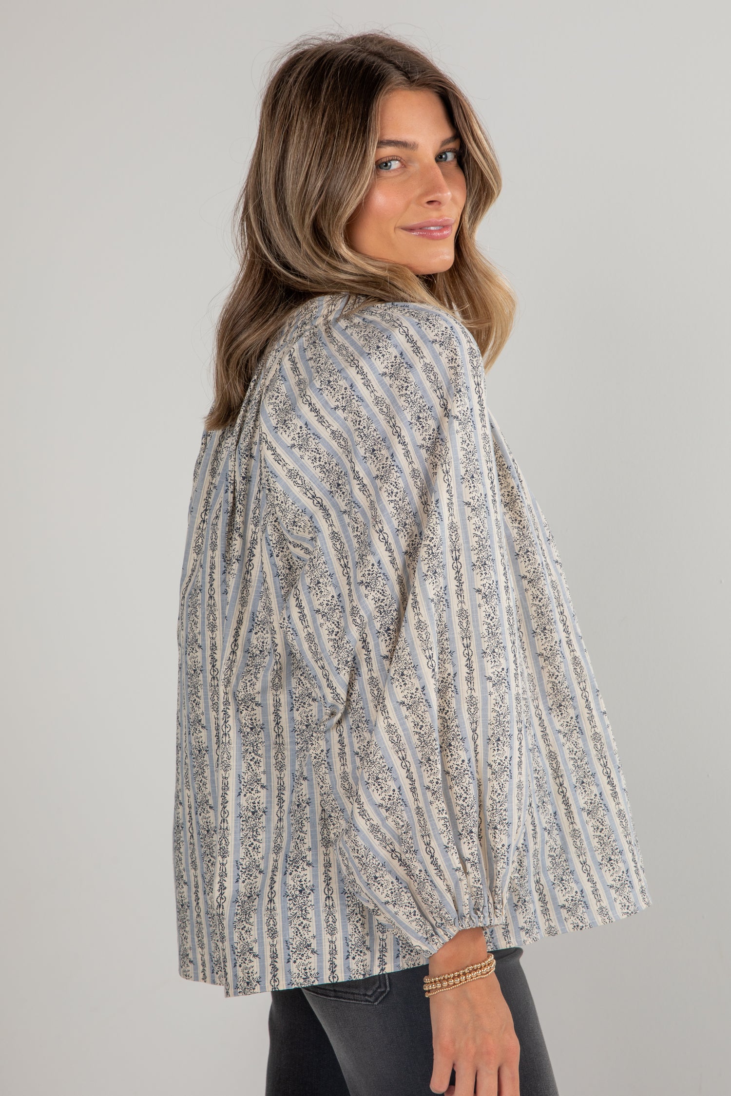 Woman wearing a patterned jacket against a plain background