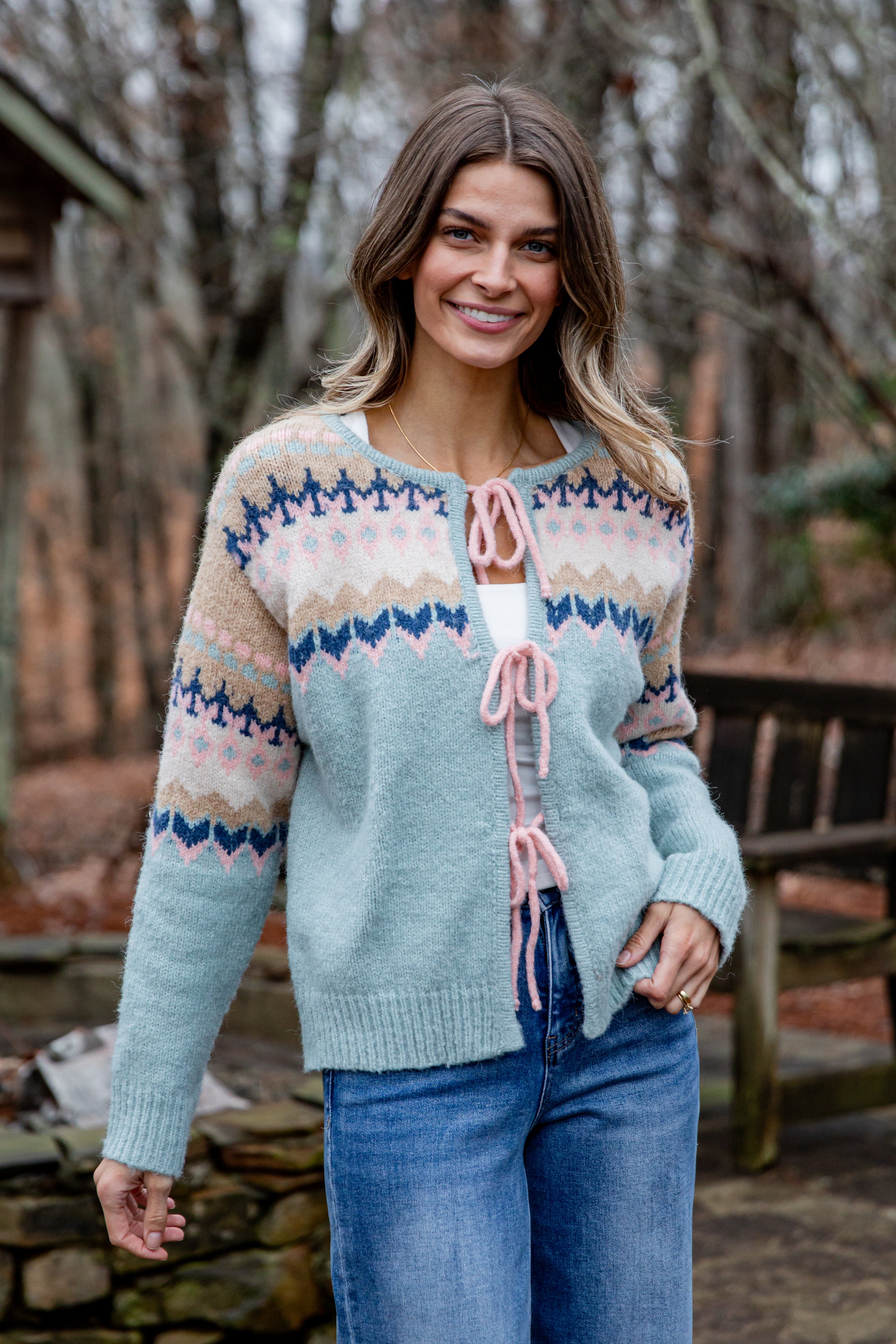 Woman wearing a patterned cardigan in a forest setting