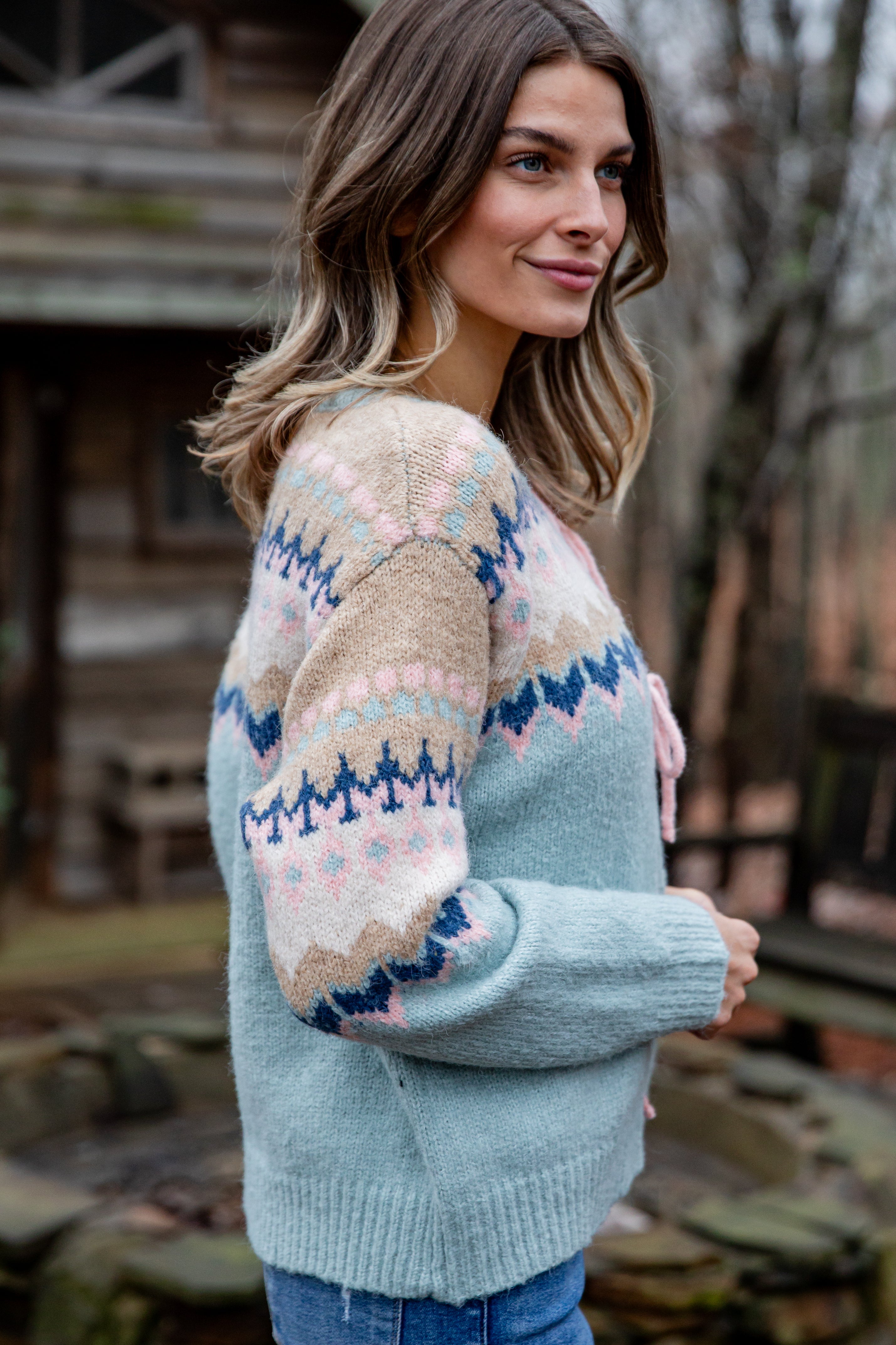 Woman wearing a patterned sweater in an outdoor setting