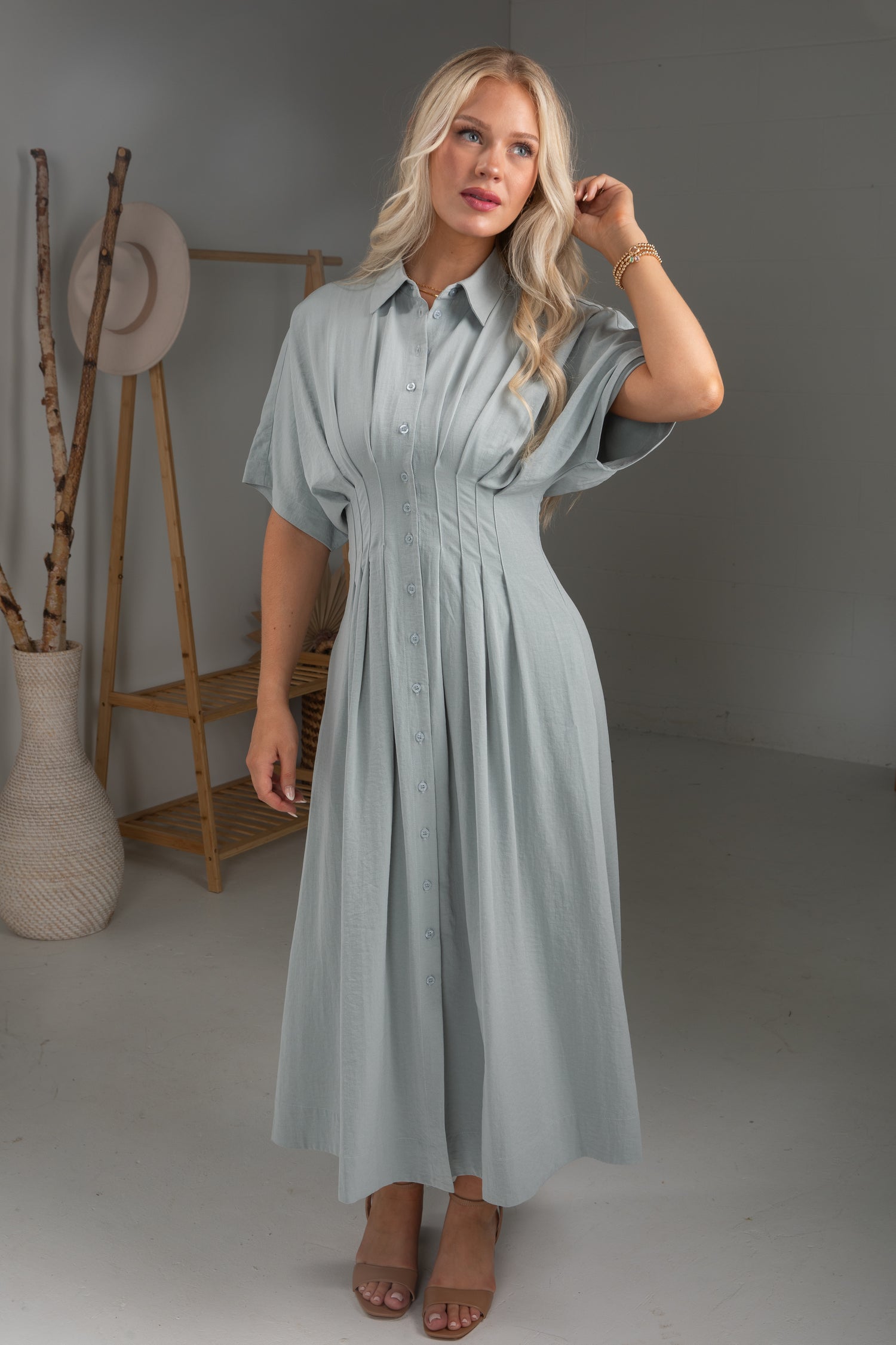 Woman wearing a light blue dress in a minimalistic room.