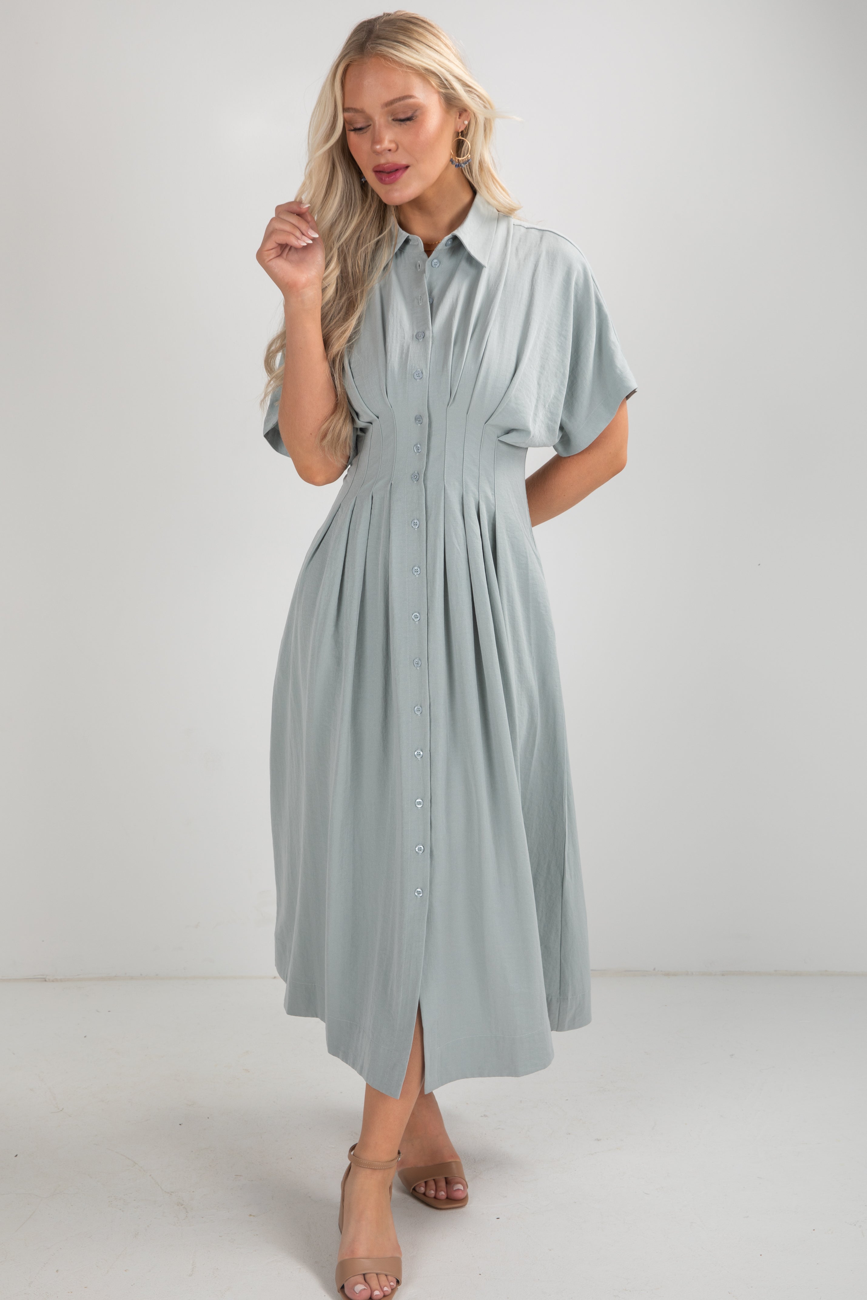 Woman wearing a light blue dress against a white background