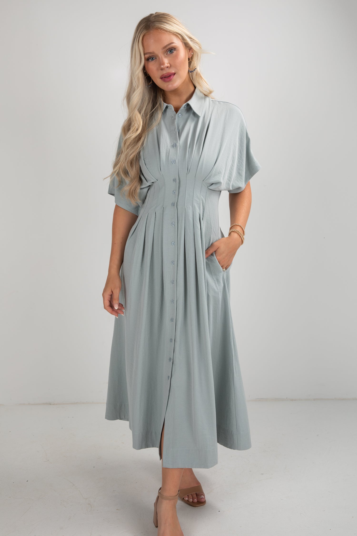 Woman wearing a light blue dress against a white background