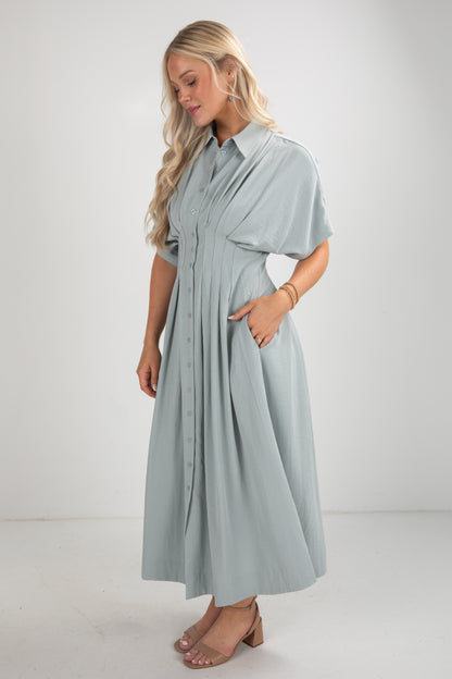 Woman wearing a light blue dress with a plain background