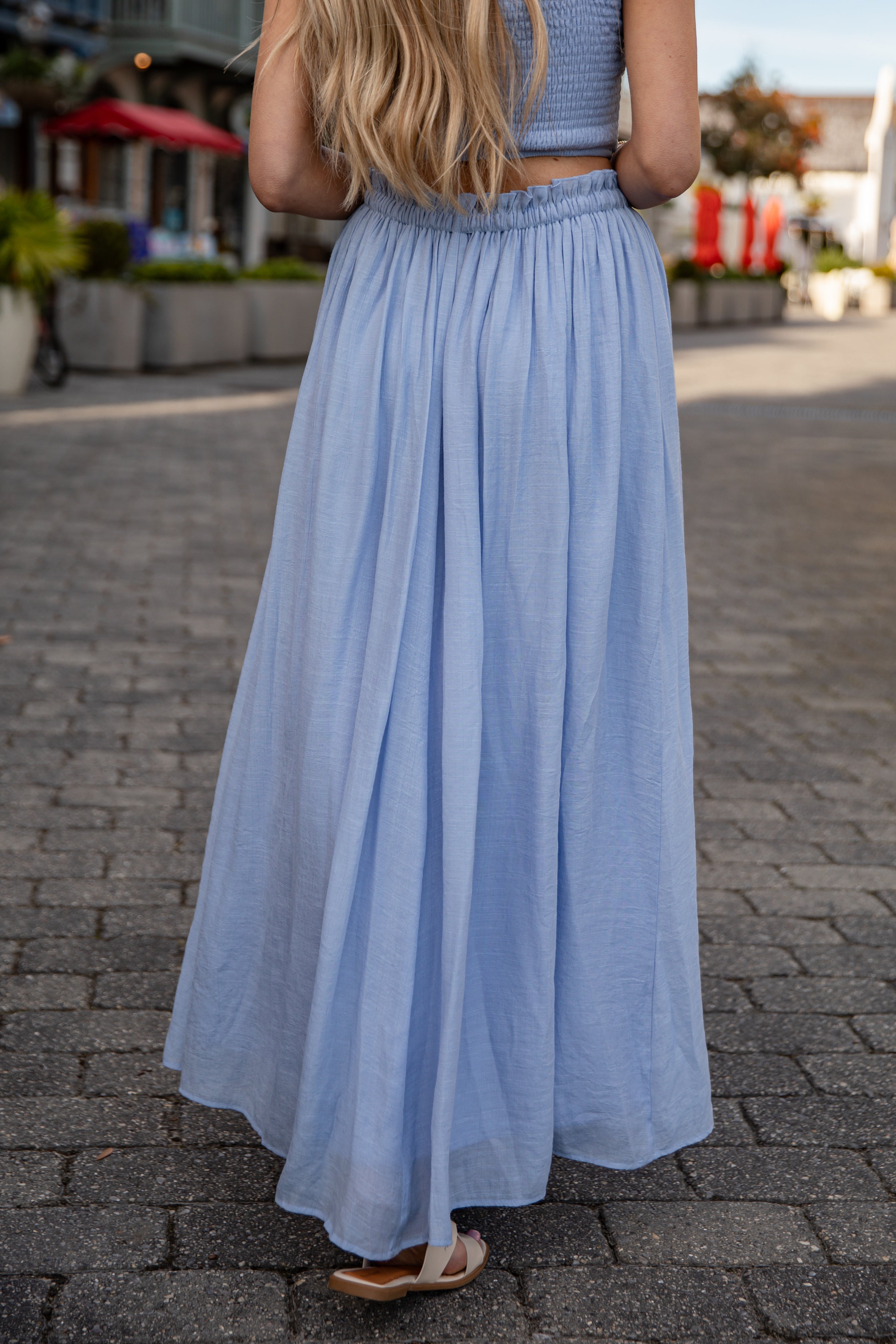 Woman wearing a light blue dress on a street.