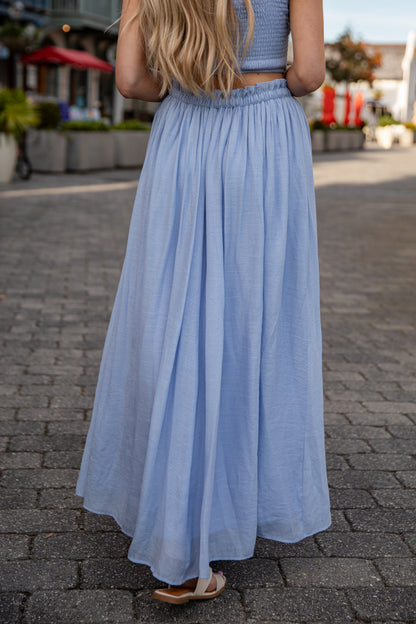 Woman wearing a light blue dress on a street.