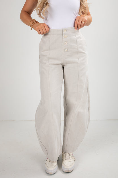 Person wearing light gray pants and white sneakers on a white background