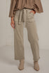 A model wearing a pair of wide-leg, straight-fit jeans in a light taupe-beige color. The jeans feature a matching fabric tie belt at the waist, side pockets, and a relaxed, straight-leg silhouette.