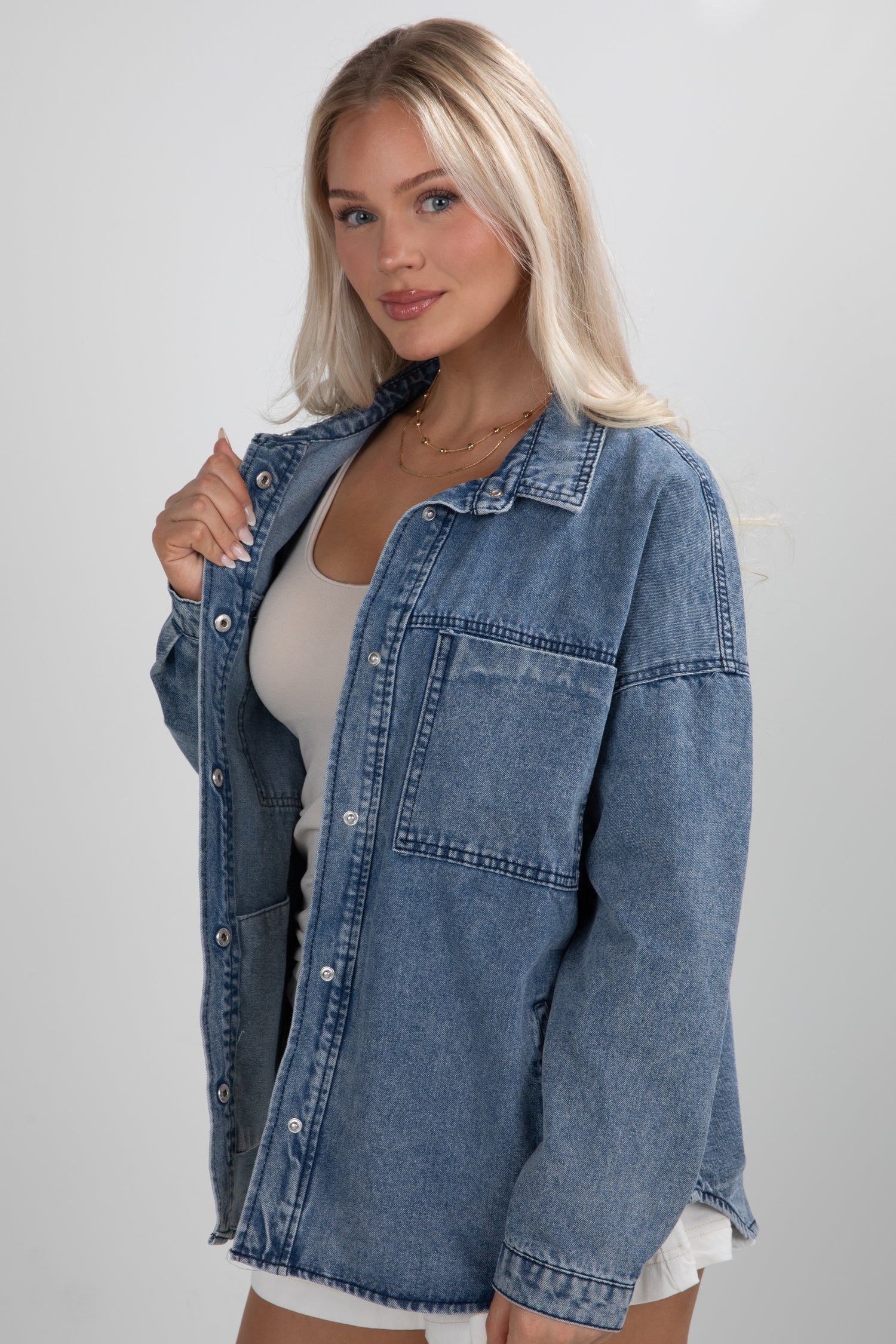 Woman wearing a denim jacket on a plain background