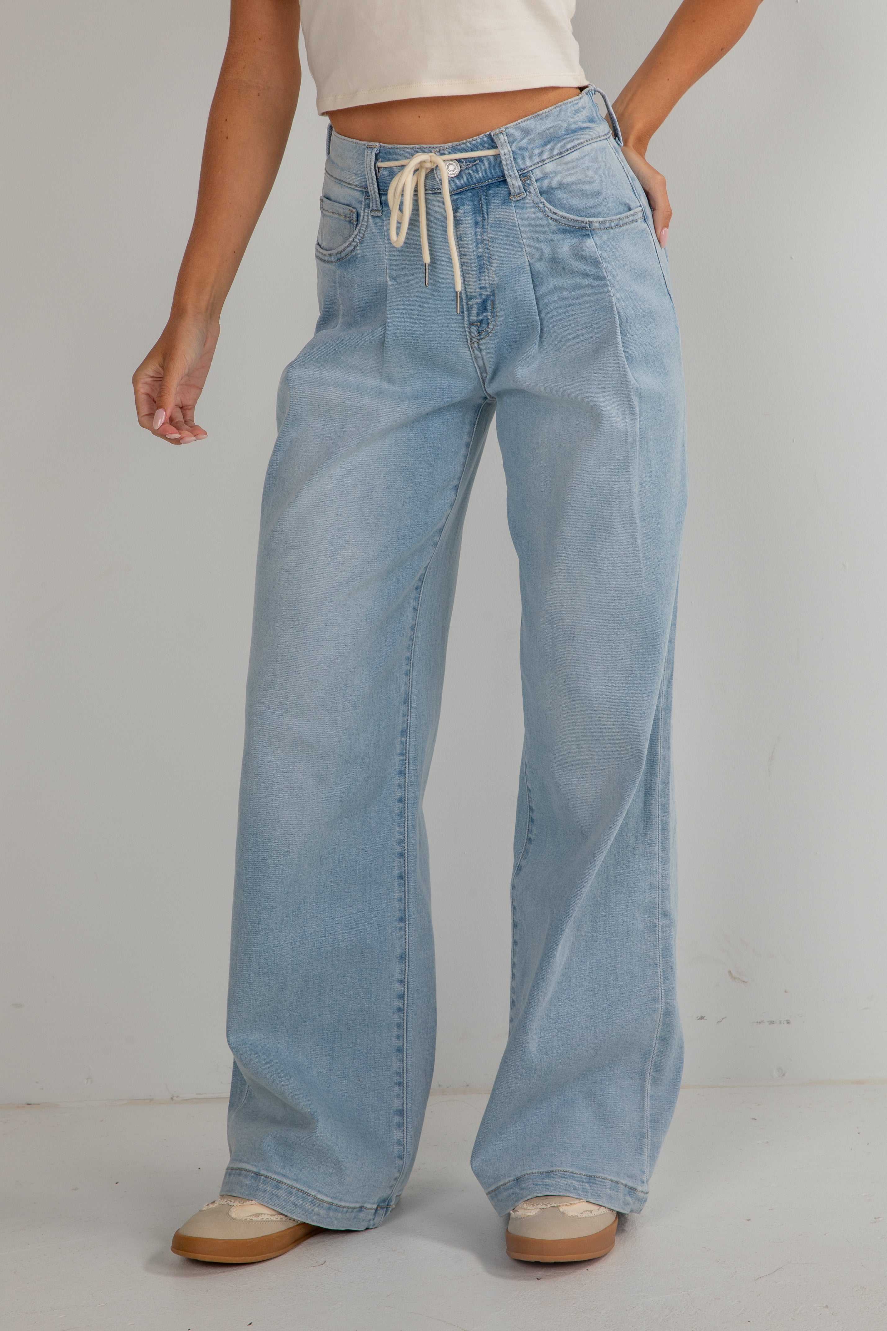 Light blue jeans worn by a person on a plain background