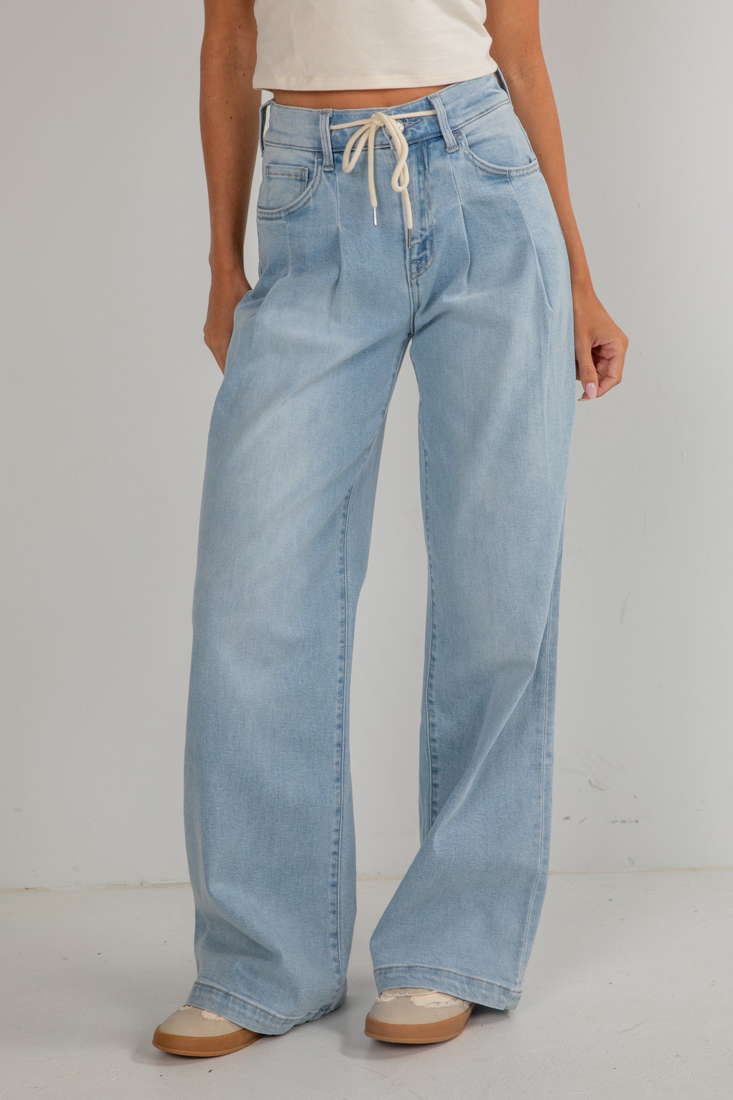 Light blue jeans worn by a person on a plain background