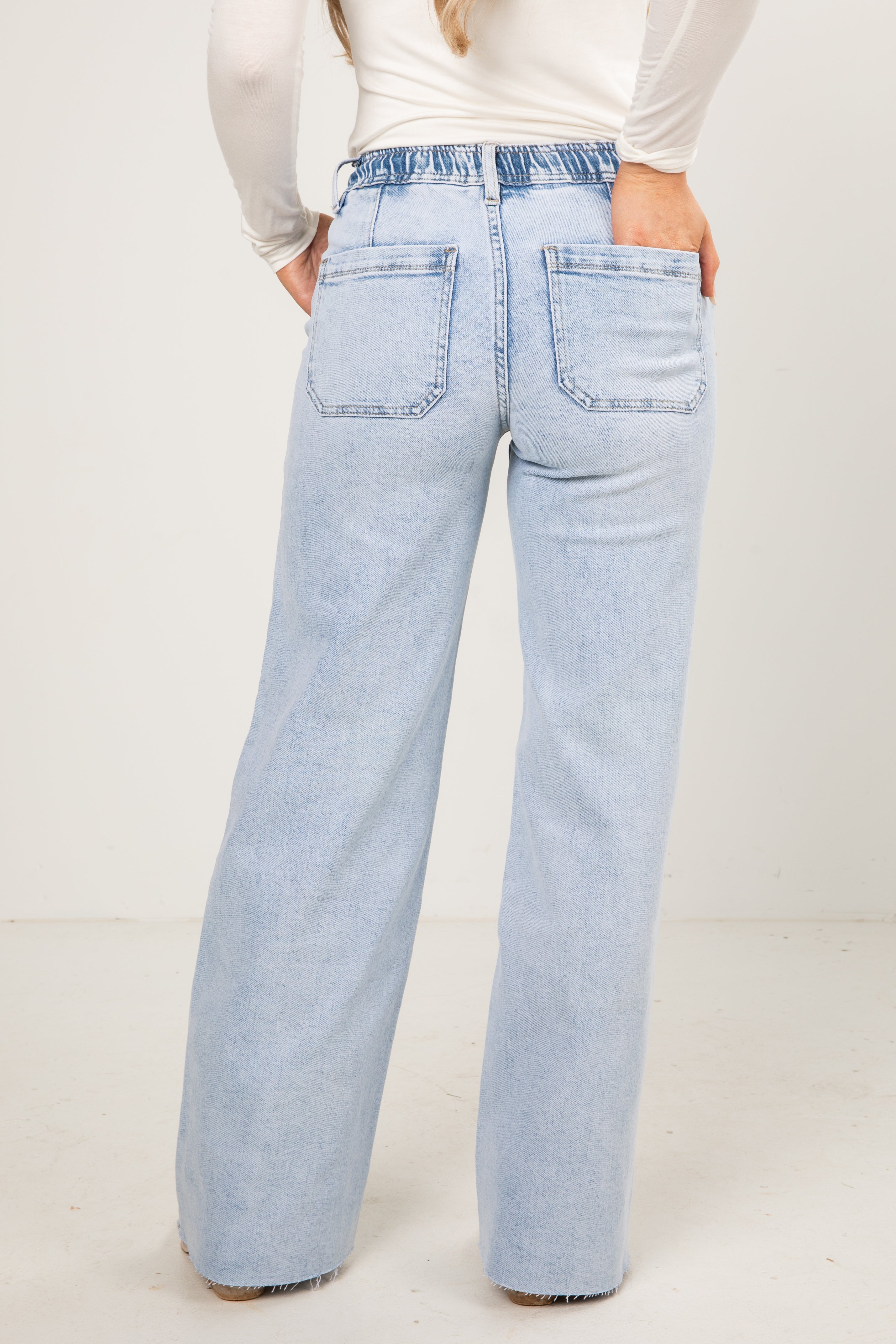 Light blue jeans worn by a person on a white background