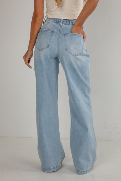 Light blue jeans worn by a person on a plain background