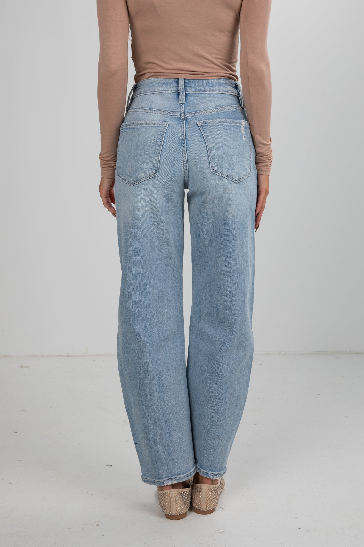 Light blue jeans worn by a person on a white background