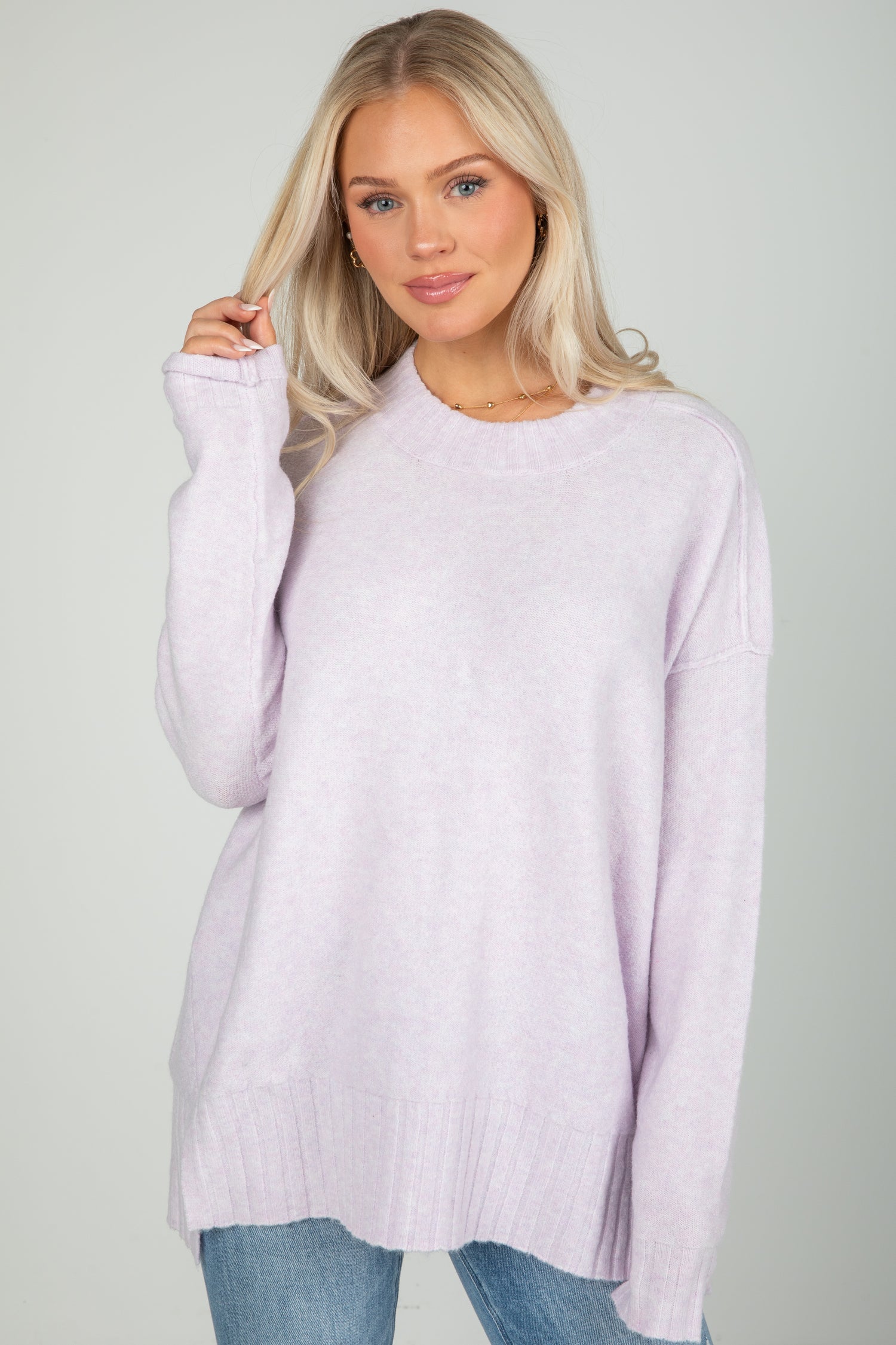 Woman wearing a light purple sweater against a plain background